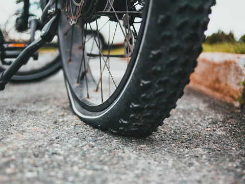 Platter Reifen am Vorderrad eines Mountainbikes, der Mantel liegt flach auf dem Asphalt auf