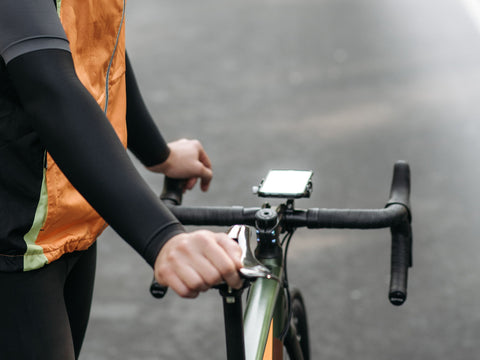 Radfahrer am Rennradlenker, Smartphone in einer Halterung mittig über dem Vorbau