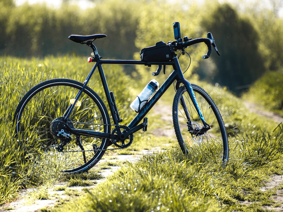 Gravelbike auf einem Feldweg, Trinkflasche im Flaschenhalter am Sitzrohr