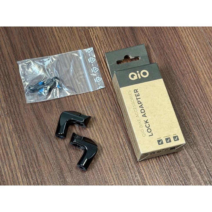 QiO Lock Adapter mit Befestigungsschrauben und Verpackung auf unserem Werkstatttresen